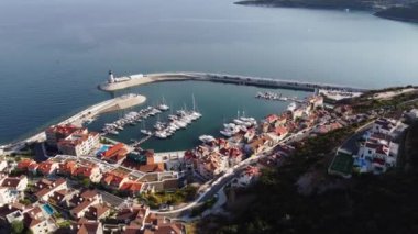 Lustica Körfezi, Adriyatik denizi, Karadağ 'ın havadan görünüşü. Binaların üst manzarası, liman limanı, demirli tekneler, yatlar ve deniz feneri, dağların arka planında. Yeni modern lüks tatil köyü.