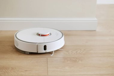 Kablosuz özerk akıllı robot elektrikli süpürge oturma odasında yerleri modern fayanslarla süpürüyor. Otomatik itişli temizlik robotu. Yer temizleme sistemi. Ev kumandası aygıtları