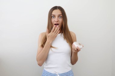 Saç dökülme sorunu olan hayal kırıklığına uğramış genç bir kadın saç fırçası tutuyor ve taradıktan sonra düşmüş saçlarını gösteriyor. Alopecia, endokrin bozukluğu, hormonal dengesizlik, doğum sonrası dönem, stres konsepti