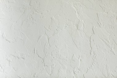 Beton duvarda beyaz alçı dokusu, el yapımı. Düzensiz yüzeyi ve tahılı olan modern bir sıva. İnşaat, iç ya da dış tasarım. Grunge Gri çimento yapısının arka planı, pürüzlü üst