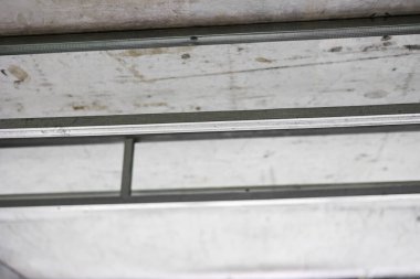 Tamamlanmamış yenileme odasındaki asılmış tavan için metalden yapılmış tavan iskeleti. Alçıpan korkulukları kuruluyor. Alüminyum yapı. Onarımlar, konut koşullarının iyileştirilmesi.