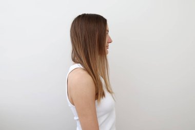 Genç bir kadının profiline göre uzun, sorunlu saçlarını gösteriyor. Sağlıksız, dağınık, arka planda izole. Kız sorunlu saç tipi. Spit, saç fırçalama tarzını kurutuyor. Saç bakım konsepti