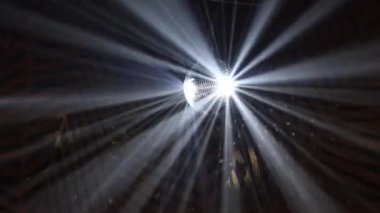 Disko topu ve gece kulübünde dönen yansıyan hareket eden ışınlar. Dönen ayna disko topunun projektörü, duvarlarda ve tavanda beyaz ışık yansıması. Parti konsepti