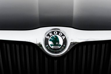 Rivne, Ukrayna, 9 Ağustos 2023. Krom ızgara arabaların üzerindeki yeşil skoda logosunu kapat. Siyah araba kaputunun logosu. Avrupalı Çek otomobil üreticisi. Kanatlı okla damgalanmış amblem