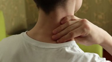 Boyun ve omuz ağrısı çeken, eklem rahatsızlığı çeken, dokunan ve masaj yapan tanınamaz haldeki genç çocuğun arka görüntüsü. Sağlık ve vücut sorunu kavramı kötü duruştan kaynaklanıyor