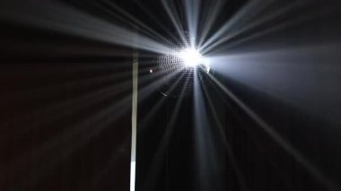 Disko topu ve gece kulübünde dönen yansıyan hareket eden ışınlar. Dönen ayna disko topunun projektörü, duvarlarda ve tavanda beyaz ışık yansıması. Parti konsepti