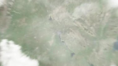 Dünya uzaydan Jining, Çin 'e yakınlaşır. Arkasından bulutlar ve atmosferden uzaya zum geliyor. Uydu görüntüsü. Seyahat girişi