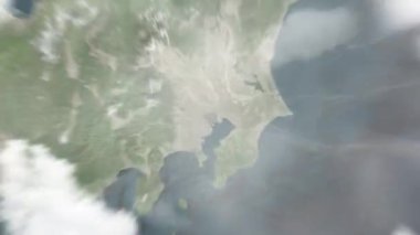Dünya uzaydan Tokyo 'ya, Japonya Tokyo İstasyonu' na yakınlaşır. Arkasından bulutlar ve atmosferden uzaya zum geliyor. Uydu görüntüsü. Seyahat girişi