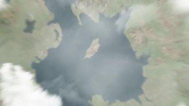 Dünya uzaydan Douglas 'a, Man Adası' na yakınlaşır. Arkasından bulutlar ve atmosferden uzaya zum geliyor. Uydu görüntüsü. Seyahat girişi