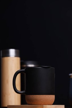 Siyah kahve fincanı ve tahtadan tabanı.