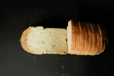Slice of bread falling on a black background. Food concept.