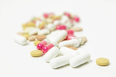 Beyaz arka planda haplar ve kapsüller. Ön plana odaklan, yumuşak bokeh.