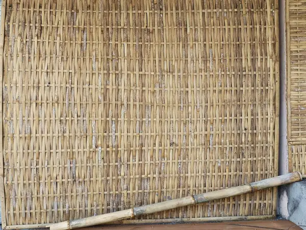 Doğal dokuma bambu ekran egzotik Asya arkaplan dokusu. Altında büyük bir bambu çubuğu olan eski dokuma bambu ekran.