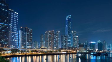 Geceleri Hong Kong 'da yüksek binalar ve limanlar.