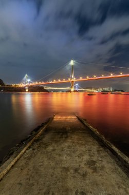 Geceleri Jetty ve Hong Kong Köprüsü 'nün Idyllic manzarası