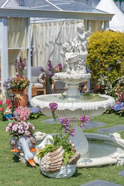 Sculpture of angel and fountain in backyard flower garden