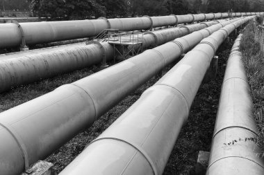 Ham petrol fabrikasındaki uzun çelik borular. Sanayi geçmişi