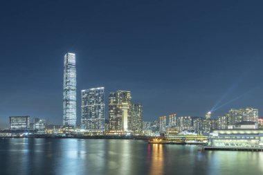 Gökdelenin, gökyüzünün ve Hong Kong limanının gece manzarası.