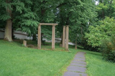 Avrupa 'da yeşil bir şehir parkının merkezindeki taş kolonlar. Harabeler, yıkılmış mimari.