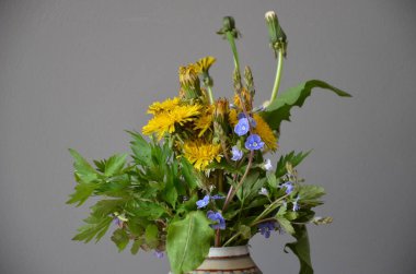 Koyu gri arkaplanda vazoda mavi çiçekler..