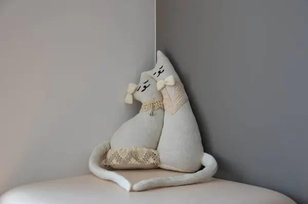 Yatağında yastığı olan beyaz bir kedi.