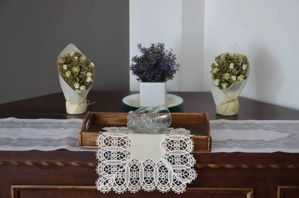 Beyaz çiçekler, mumlar, vazoda bir buket gül.