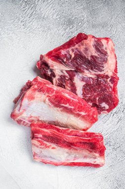 Biftek, pirzola, mutfak masasında çiğ et. Beyaz arka plan. Üst görünüm.