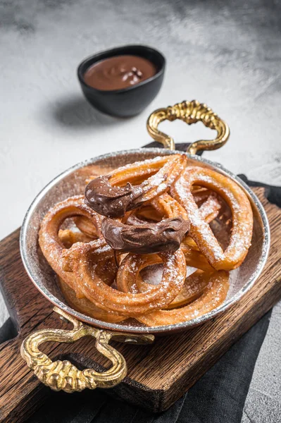 Çikolatalı Churros tavada tipik İspanyol tatlı atıştırmalığı. Gri arka plan. Üst görünüm.