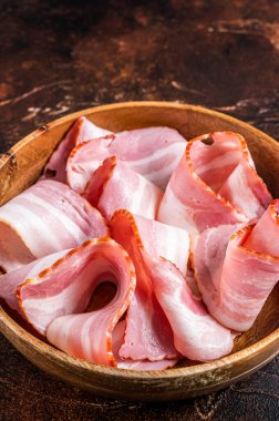 Ahşap tabakta tütsülenmiş pastırma. Karanlık arka plan. Üst görünüm.