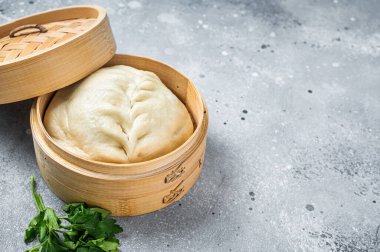 Pyanse steamed bun in a Bamboo steamer, korean street food. Gray background. Top view. Copy space.