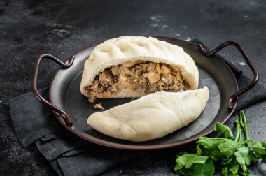 National Korean fast food - steamed pies pyan-se Pyanse with vegetable and meat. Black background. Top view.