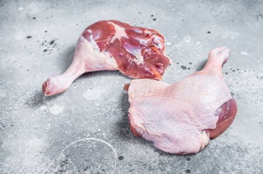 Fresh raw duck legs on a kitchen table. Gray background. Top view.