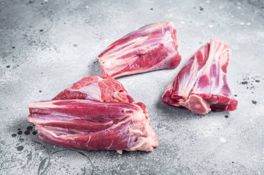 Uncooked Raw lamb shanks, mutton meat on kitchen table. Gray background. Top view.