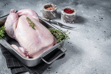 Mutfak tepsisinde otlu çiğ tavuk. Gri arka plan. Üst Manzara. Boşluğu kopyala.