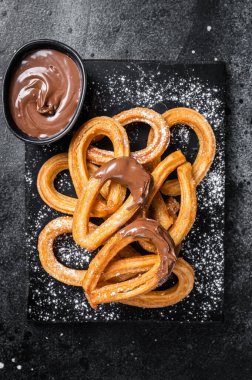 Geleneksel Meksika usulü çikolatalı churros. Siyah arka plan. Üst görünüm.