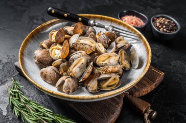 Buharda pişirilmiş midye ekmeği ve şifalı otlar. Siyah arka plan. Üst görünüm.