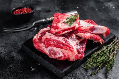 Dana eti, pirzola, mermer panoda çiğ pirzola. Siyah arka plan. Üst görünüm.