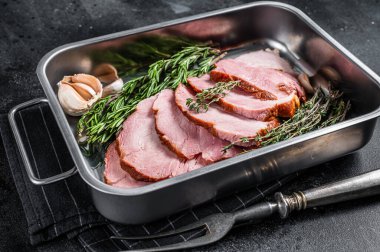 Çelik üçlüde ev yapımı domuz eti, kekik ve biberiyeli. Siyah arka plan. Üst görünüm.