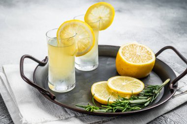 Traditional italian limoncello liqueur, lemon alcohol Digestive with lemon and rosemary. White background. Top view.
