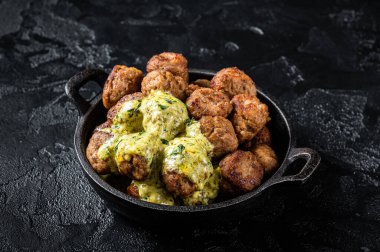 Skillet with Swedish beef Meatballs with Cream Sauce. Black background. Top view.