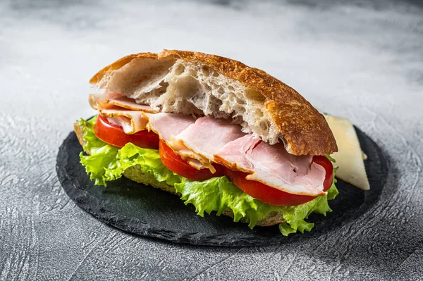Fresh and healthy turkey sandwich with white cheese, tomato and Lettuce in white bread. White background. Top view.