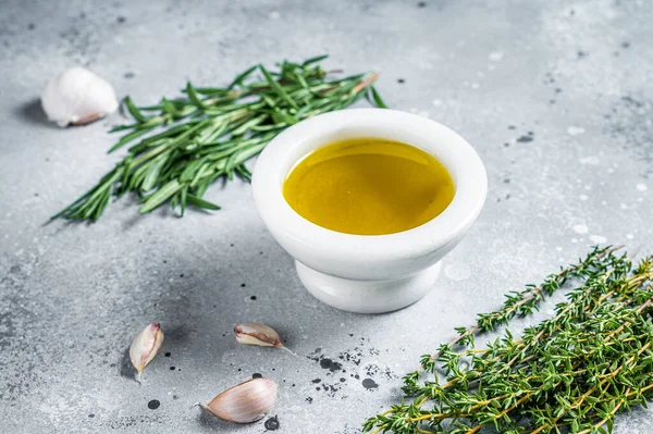 Olive oil with fresh herbs on kitchen table. Top view. Copy space.