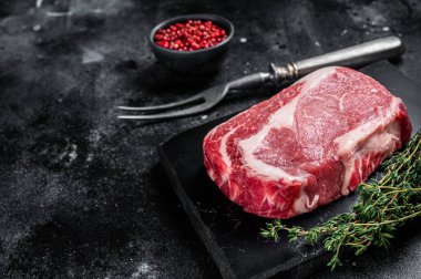 Pirzola, çiğ biftek, kekik ve pembe tuzlu sığır eti. Siyah arka plan. Üst Manzara. Boşluğu kopyala.