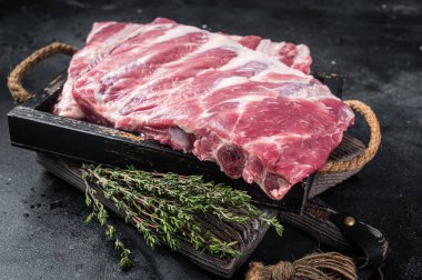 Çiğ domuz pirzolası ve şifalı otlar. Siyah arka plan. Üst görünüm.