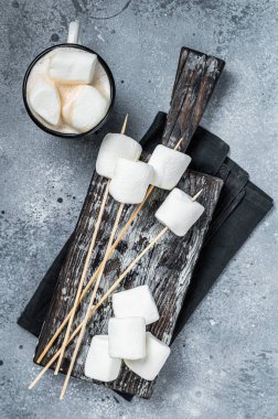 Marshmallow on the stick ready for BBQ. Gray background. Top view.