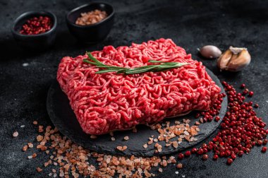 Uncooked beef veal Mince Meat, raw ground meat. Black background. Top view.