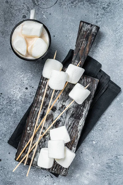 Marshmallow on the stick ready for BBQ. Gray background. Top view.