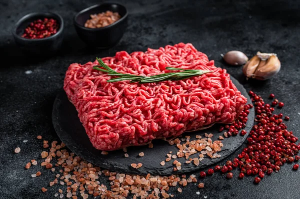 Uncooked beef veal Mince Meat, raw ground meat. Black background. Top view.