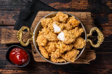 Ev yapımı patlamış mısır tavuğu tavada ısırığı. Ahşap arka plan. Üst görünüm.