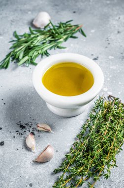Olive oil with fresh herbs on kitchen table. Top view. Copy space.